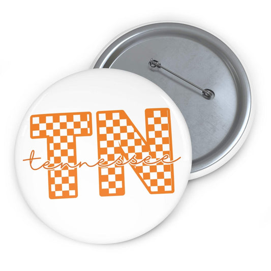 Tennessee TN Checkerboard pin button with orange and white check pattern and scripted text on glossy round metal surface