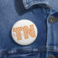 Tennessee TN Checkerboard pin button with orange and white checkered pattern and cursive text on glossy white metal surface attached to denim jacket