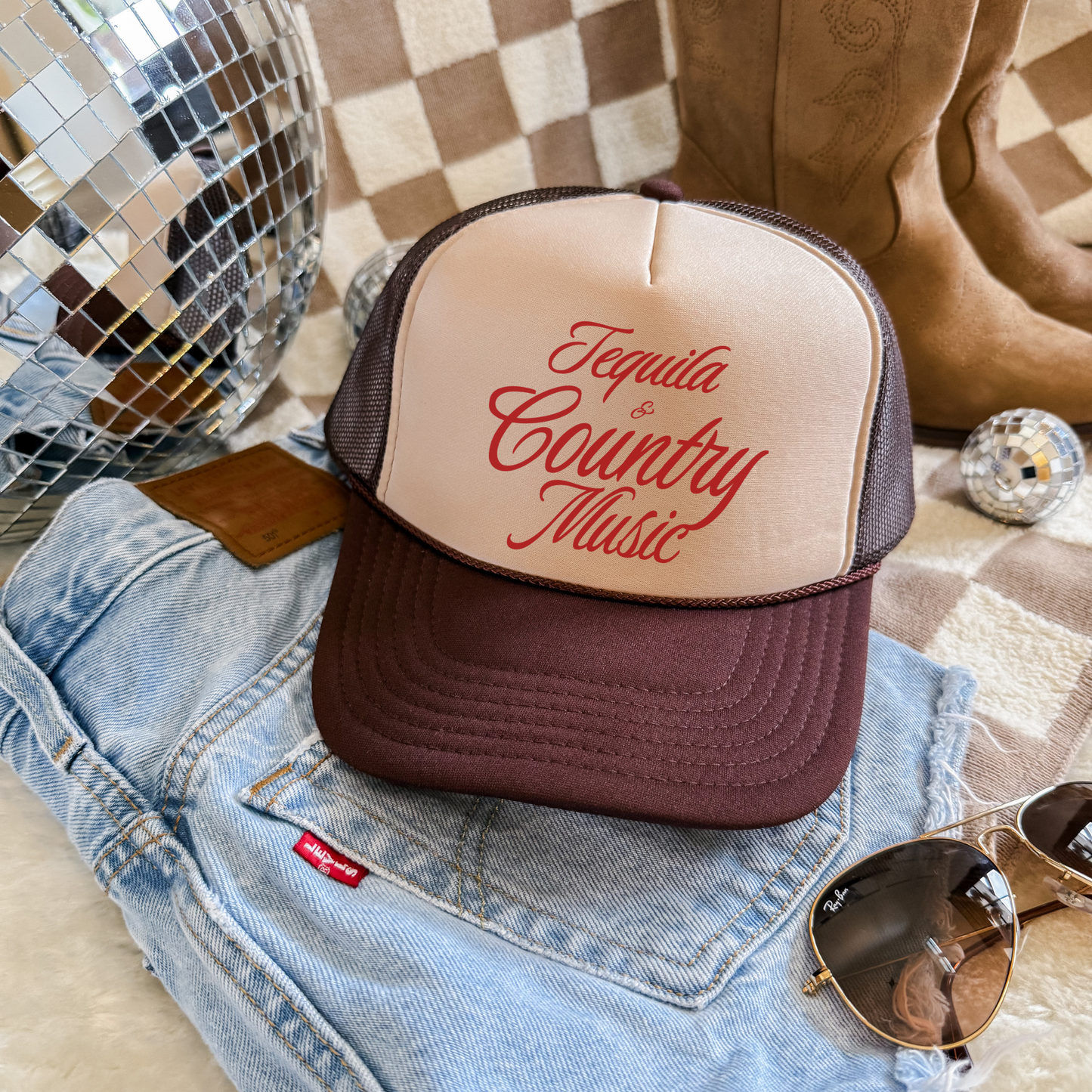 Trucker hat with beige structured front, brown mesh back and brim, featuring Tequila & Country Music script in red
