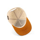 The Austin Script Hat, beige and orange trucker hat with a pre-curved orange brim and mesh back