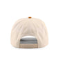 The Austin Script Hat beige cotton trucker cap with orange top button and adjustable snapback, shown from the back