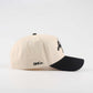 The "Austin" Script Hat in cream cotton with a black pre-curved brim and embroidered script logo