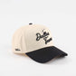 The Dallas Script Hat, beige and black pre-curved trucker cap with embroidered Dallas script and black brim