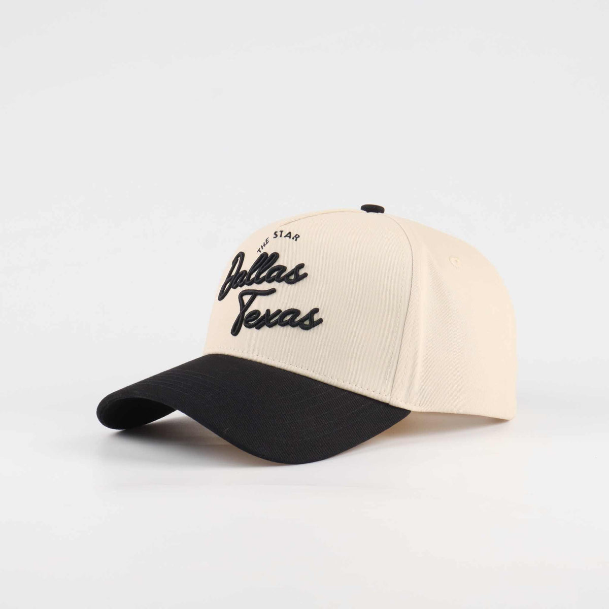 The Dallas Script Hat in beige and black cotton with Dallas Texas script embroidery and a pre-curved brim