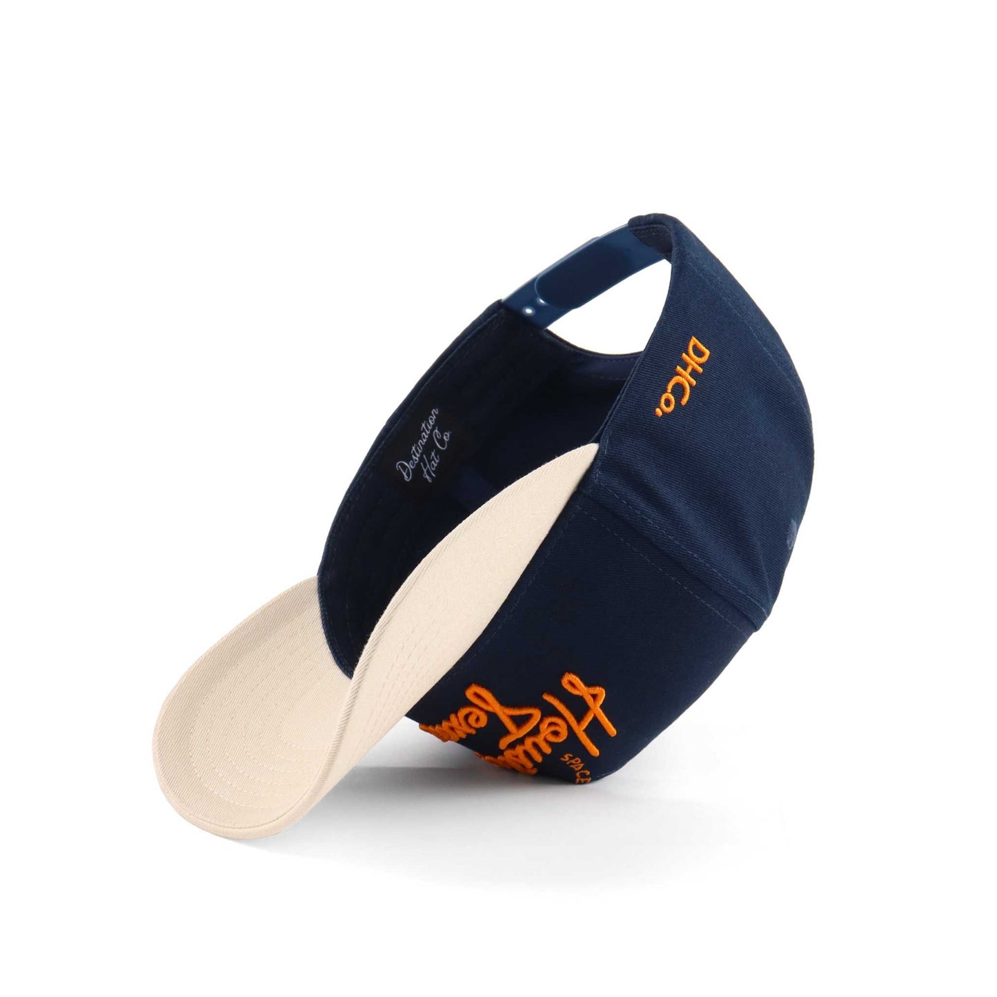 The "Houston" Script Hat in navy and beige with orange embroidered script, curved brim, and trucker mesh