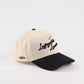 The Lafayette Script Hat, beige cotton cap with black embroidered script, black pre-curved brim and low-profile fit