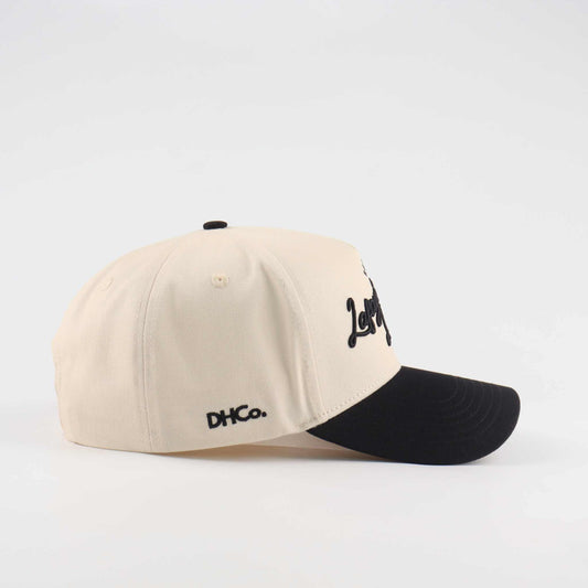 The Lafayette Script Hat in beige and black cotton with embroidered script, pre-curved brim, and fitted low-profile design