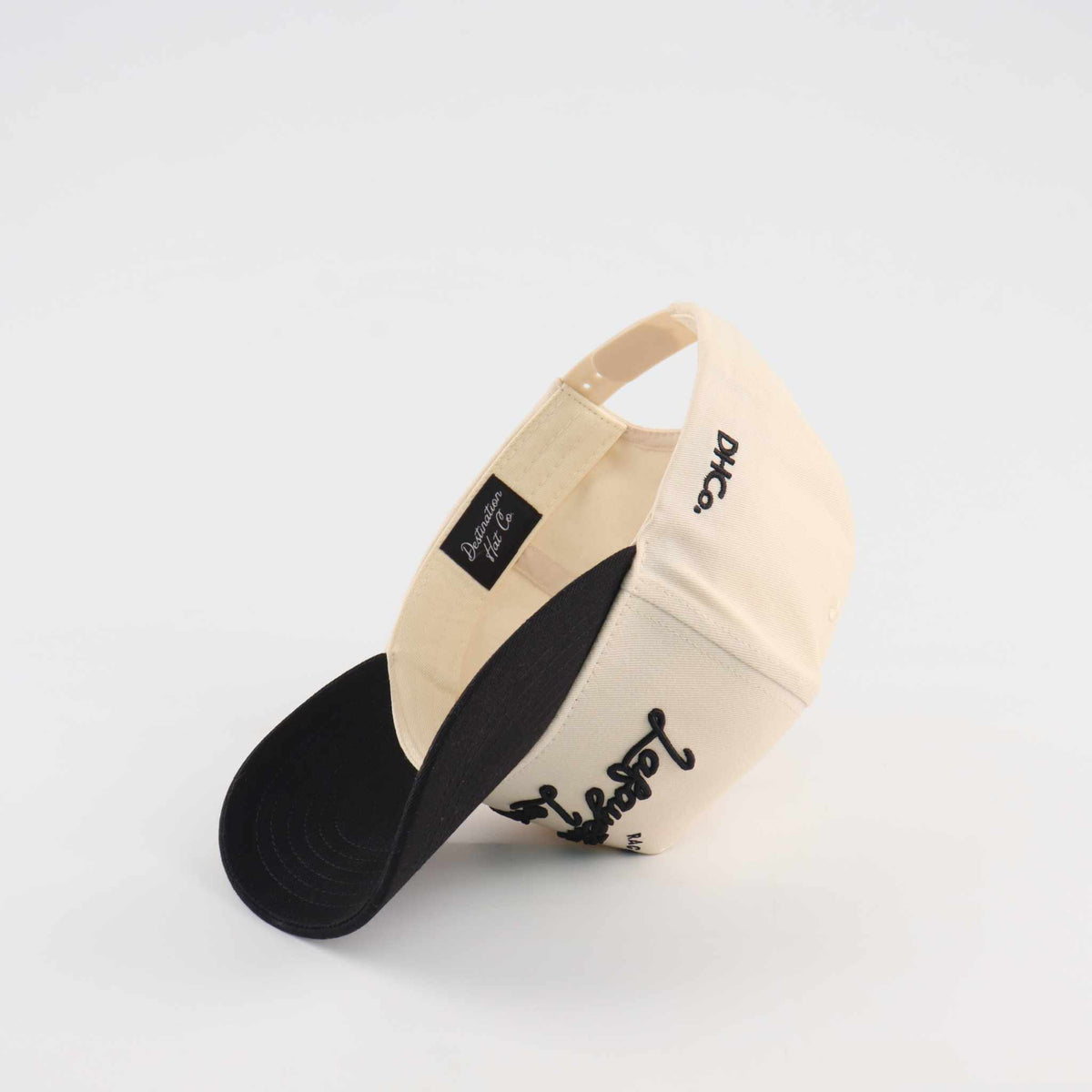 The Lafayette Script Hat, beige and black cotton trucker cap with embroidered script and pre-curved brim