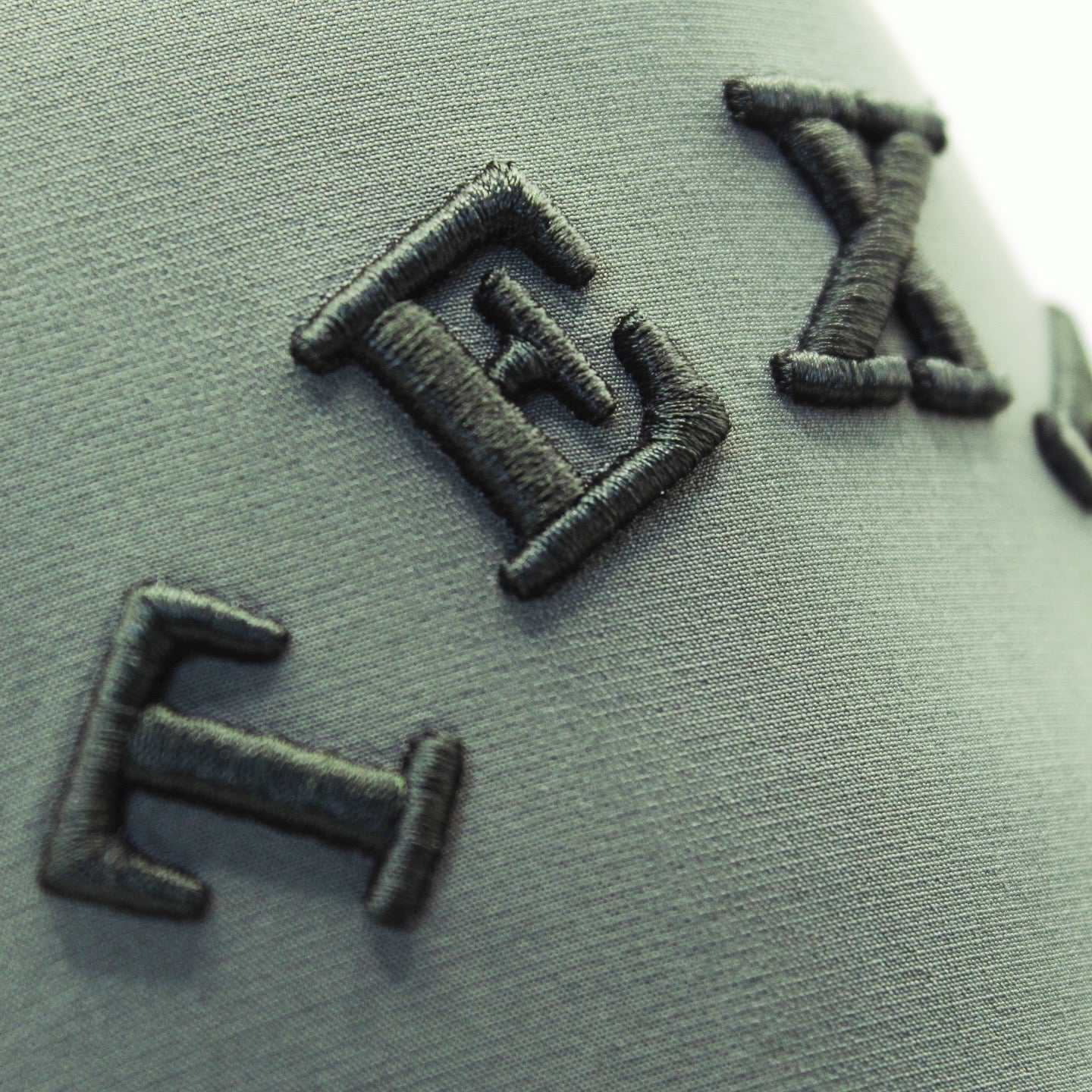 The Texas Performance Snapback in olive green nylon-spandex with raised black embroidered lettering