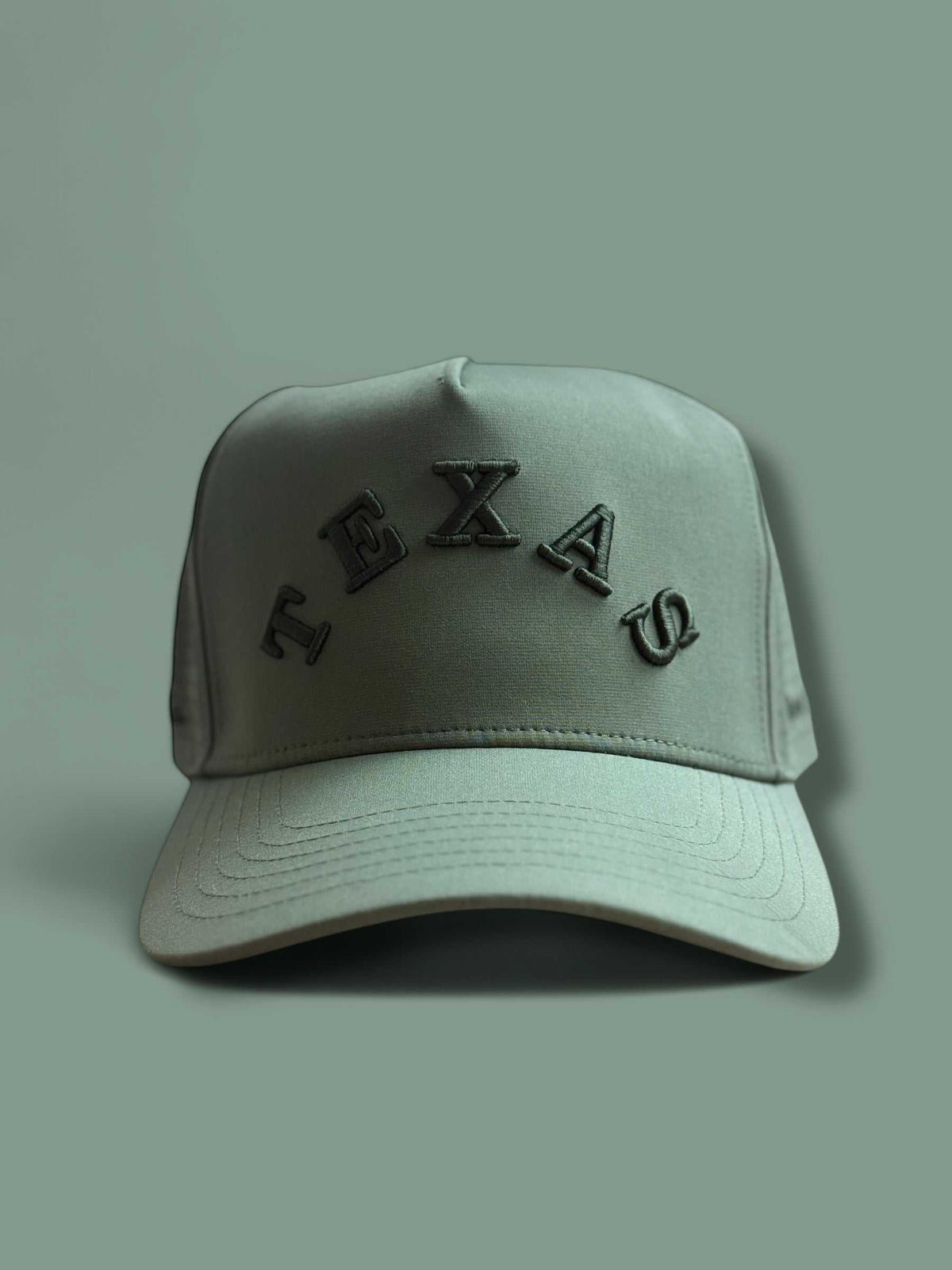 The Texas Performance Snapback olive green nylon-spandex cap with curved brim and raised TEXAS lettering