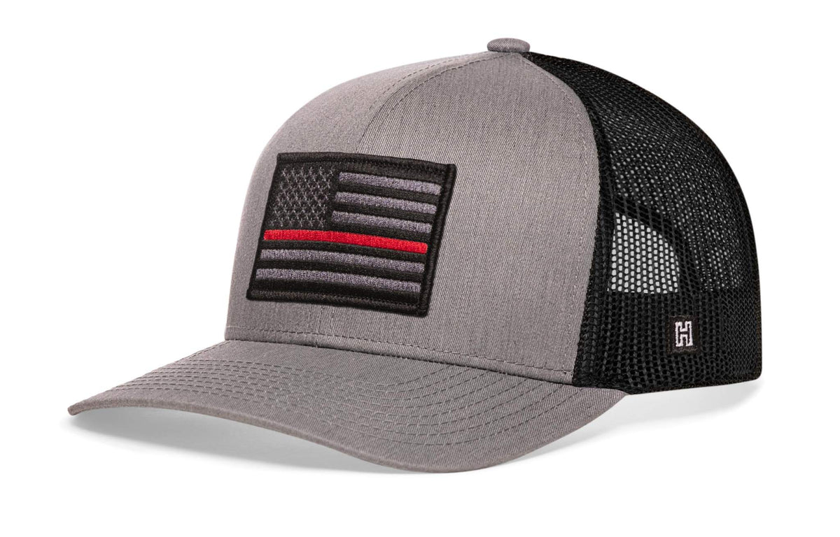 Thin Red Line Trucker Hat with grey front panel, black mesh back, and embroidered black and grey American flag patch with red line.