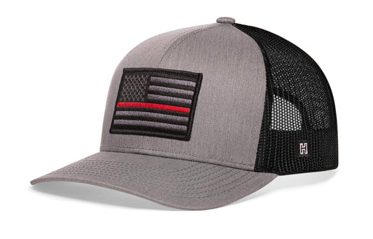 Thin Red Line Trucker Hat with grey front panel, black mesh back, and embroidered black and grey American flag patch with red line.