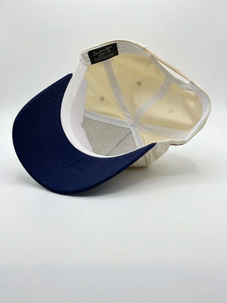 U.S.A Script Hat in beige and navy blue, with a mesh back, curved brim, and adjustable snap closure