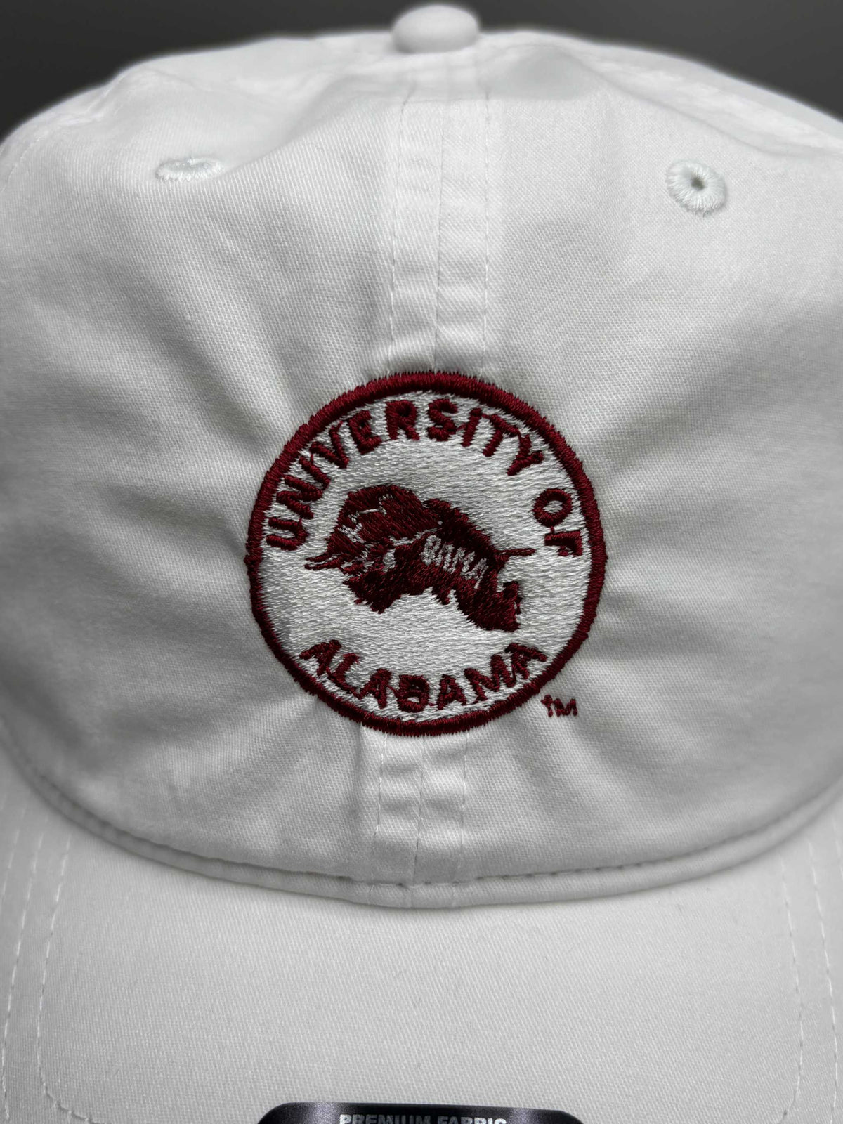 University of Alabama white cotton unstructured hat with embroidered crimson circular logo and adjustable strapback